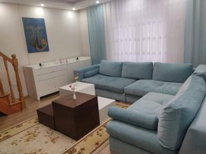 a living room with a blue couch and a table at Duplex 41 in the city center of Umraniye Alemdag caddesi Istanbul in Sarıgazi