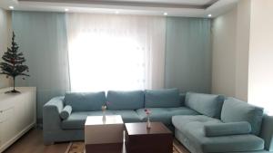 a living room with a blue couch and a christmas tree at Duplex 41 in the city center of Umraniye Alemdag caddesi Istanbul in Sarıgazi