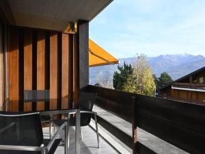 uma varanda com mesa, cadeiras e montanhas em Studio Orion RS6 by Interhome em Ovronnaz