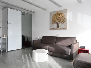 uma sala de estar com um sofá e uma pintura de árvore na parede em Studio Orion RS6 by Interhome em Ovronnaz