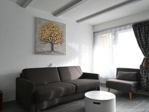 a living room with a couch and a tree picture on the wall at Studio Orion RS6 by Interhome in Ovronnaz +9 photos