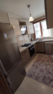 a kitchen with a stainless steel refrigerator and a sink at Duplex 41 in the city center of Umraniye Alemdag caddesi Istanbul in Sarıgazi