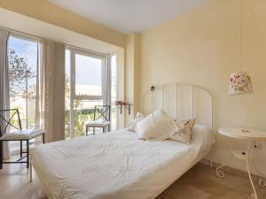 een slaapkamer met een wit bed en een balkon bij Apartment Carnaval by Interhome in Isla Cristina