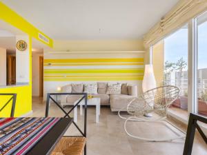 a living room with a yellow and white striped wall at Apartment Carnaval by Interhome in Isla Cristina