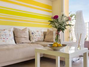 a living room with a couch and a table with flowers at Apartment Carnaval by Interhome in Isla Cristina