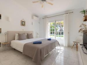 a white bedroom with a bed with blue towels on it at Villa Villa Verde by Interhome in Vilamoura