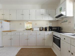 una cocina con armarios blancos y electrodomésticos blancos en Villa Villa Verde by Interhome, en Vilamoura