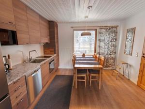 eine Küche mit einem Holztisch mit Stühlen und einem Esszimmer in der Unterkunft Holiday Home Kätkäläinen e 2 by Interhome in Sirkka