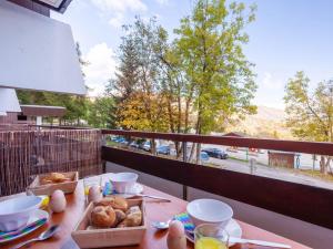 un tavolo con pane e uova su un balcone di Apartment Pegase Phenix-70 by Interhome a Le Corbier