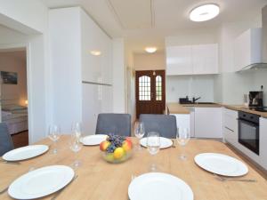 Holiday Home Mihotić by Interhome في مورتير: طاولة غرفة الطعام مع الأطباق البيضاء وكؤوس النبيذ