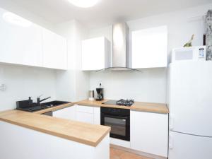 a kitchen with white cabinets and a refrigerator at Holiday Home Mihotić by Interhome in Murter
