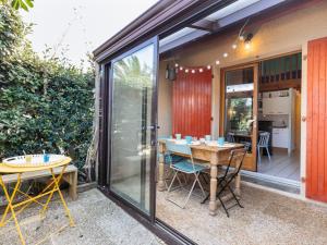 a patio with a table and chairs and a dining room at Holiday Home Plage sud-3 by Interhome in Capbreton
