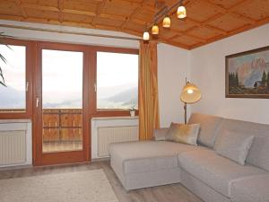 - un salon avec un canapé et de grandes fenêtres dans l'établissement Apartment Romantik Chalet Karin-3 by Interhome, à Sellrain