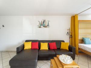 ein Wohnzimmer mit einem schwarzen Sofa und bunten Kissen in der Unterkunft Apartment le Grand Foc-1 by Interhome in Capbreton