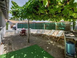 a group of chairs and a table under a tree at Holiday Home Pyrénées by Interhome in Capbreton