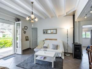 a living room with a bed and a table at Holiday Home Pyrénées by Interhome in Capbreton +13 photos