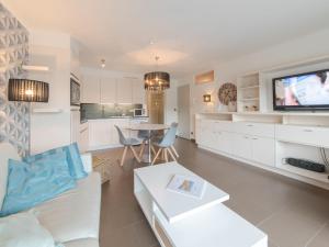 een keuken en een woonkamer met een bank en een televisie bij Apartment Sea Breeze by Interhome in Bredene