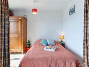 a bedroom with a bed with a red bedspread at Apartment Simiane by Interhome in La Toussuire