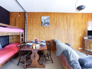 a bedroom with a table and a bunk bed at Apartment Simiane by Interhome in La Toussuire