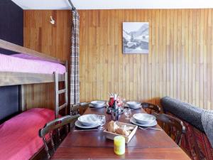 a table and chairs in a room with a bunk bed at Apartment Simiane by Interhome in La Toussuire