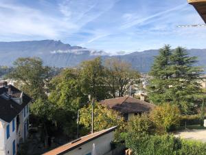 une vue d'une ville avec des montagnes en arrière-plan dans l'établissement MALIBAIX, à Aix-les-Bains