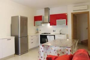 a kitchen with stainless steel appliances and red cabinets at Volturnus a soli 150m dal mare con WI FI in Marina di Castagneto Carducci