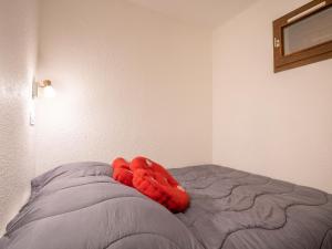 - une couverture rouge sur un lit dans une chambre dans l'établissement Studio Les Asters-37 by Interhome, aux Menuires