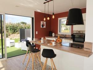 een keuken met rode muren en een aanrecht met krukken bij Holiday Home Villa Ty Coz by Interhome in Cléder