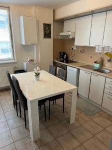 uma cozinha com uma mesa branca e cadeiras em Iren Apartment Bratislava em Bratislava