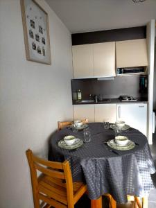una mesa de comedor con un mantel negro. en Appartement situé en plein centre à deux pas des pistes., en Besse-et-Saint-Anastaise