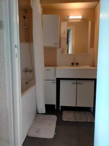 a bathroom with a tub and a sink and a mirror at Appartement situé en plein centre à deux pas des pistes. in Besse-et-Saint-Anastaise