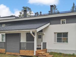 a house with a gray roof and a porch at Holiday Home Kätkäläinen 5 e 3 by Interhome in Sirkka