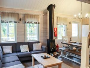 ein Wohnzimmer mit einem Sofa und einem Holzofen in der Unterkunft Holiday Home Isohukka by Interhome in Hyrynsalmi