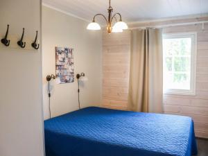 ein Schlafzimmer mit einem blauen Bett und einem Fenster in der Unterkunft Holiday Home Isohukka by Interhome in Hyrynsalmi + 21 Fotos