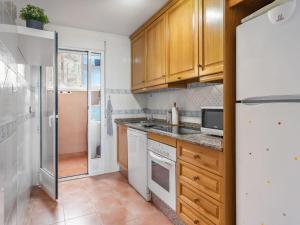 una cocina con electrodomésticos blancos y armarios de madera en Apartment Marina de la Torre by Interhome, en Mojácar