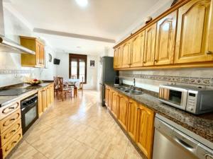 a kitchen with wooden cabinets and a dining room at Holiday Home Villa Anita by Interhome in Rincón de la Victoria