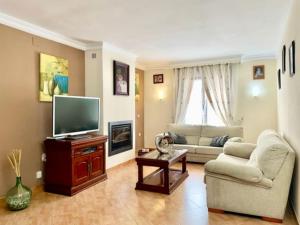 a living room with a television and a couch at Holiday Home Villa Anita by Interhome in Rincón de la Victoria