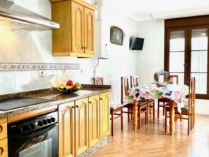 a kitchen with wooden cabinets and a dining table at Holiday Home Villa Anita by Interhome in Rincón de la Victoria