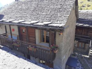 ein Haus mit einem Balkon mit Blumen darauf in der Unterkunft Holiday Home Rustico Odette by Interhome in Malvaglia