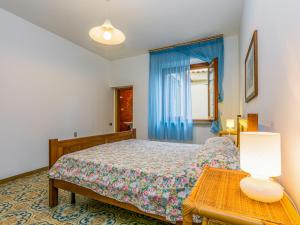 een slaapkamer met een bed en een tafel met een lamp bij Apartment Dalia by Interhome in Lamporecchio