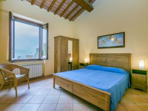 een slaapkamer met een bed, een stoel en een raam bij Apartment Girasole by Interhome in Lamporecchio