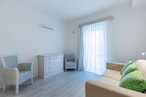- un salon avec un canapé et une commode dans l'établissement Hotel Flamingo, à Santa Margherita di Pula