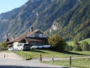 a house with a van parked in front of a mountain at Apartment Chalet Bifigen by Interhome in Kandergrund