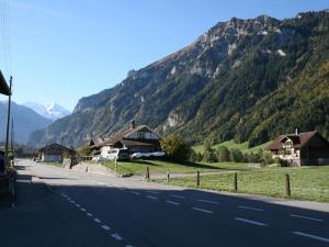 a road with houses and mountains in the background at Apartment Chalet Bifigen by Interhome in Kandergrund