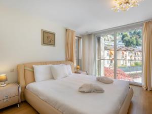 een slaapkamer met een wit bed en een groot raam bij Apartment Le Belvédère D1-4 by Interhome in Montreux