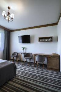 a hotel room with a bed and a table and chairs at Apartamenty Regle in Bukowina Tatrzańska