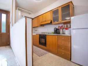 サン・ヴィート・キエティーノにあるApartment Di Italia by Interhomeのキッチン(木製キャビネット、白い冷蔵庫付)