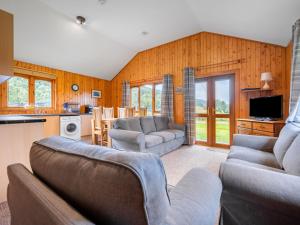 a living room with two couches and a kitchen at Divach Lodge at Lochletter Lodges in Drumnadrochit