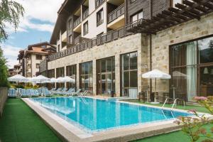 バンスコにあるTerra Complex-D4-Balkan private apartment - Golf & Skiingの建物の隣にスイミングプール(椅子、パラソル付)