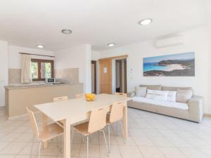una cucina e un soggiorno con tavolo e sedie di Holiday Home Villa 10 A by Interhome a Costa Paradiso